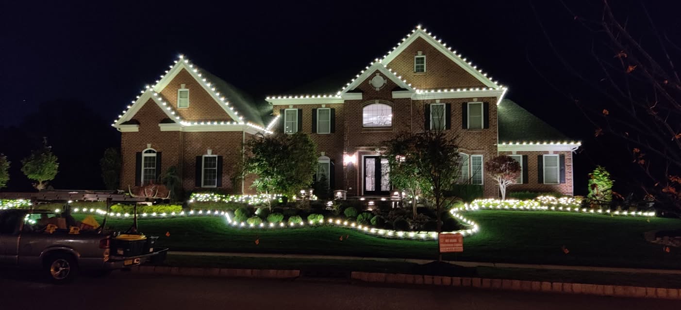 Wide home with warm white roofline and shrub lights