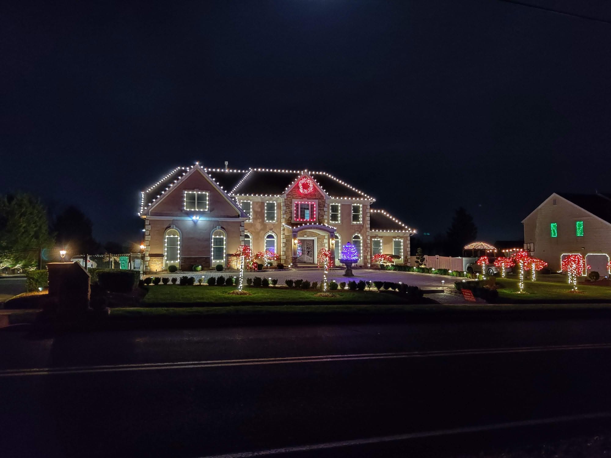 Home with white roofline Christmas lights at dusk