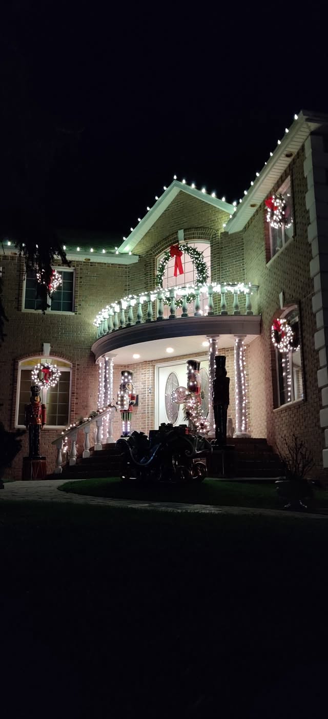 Home peak outlined in green and white Christmas lights