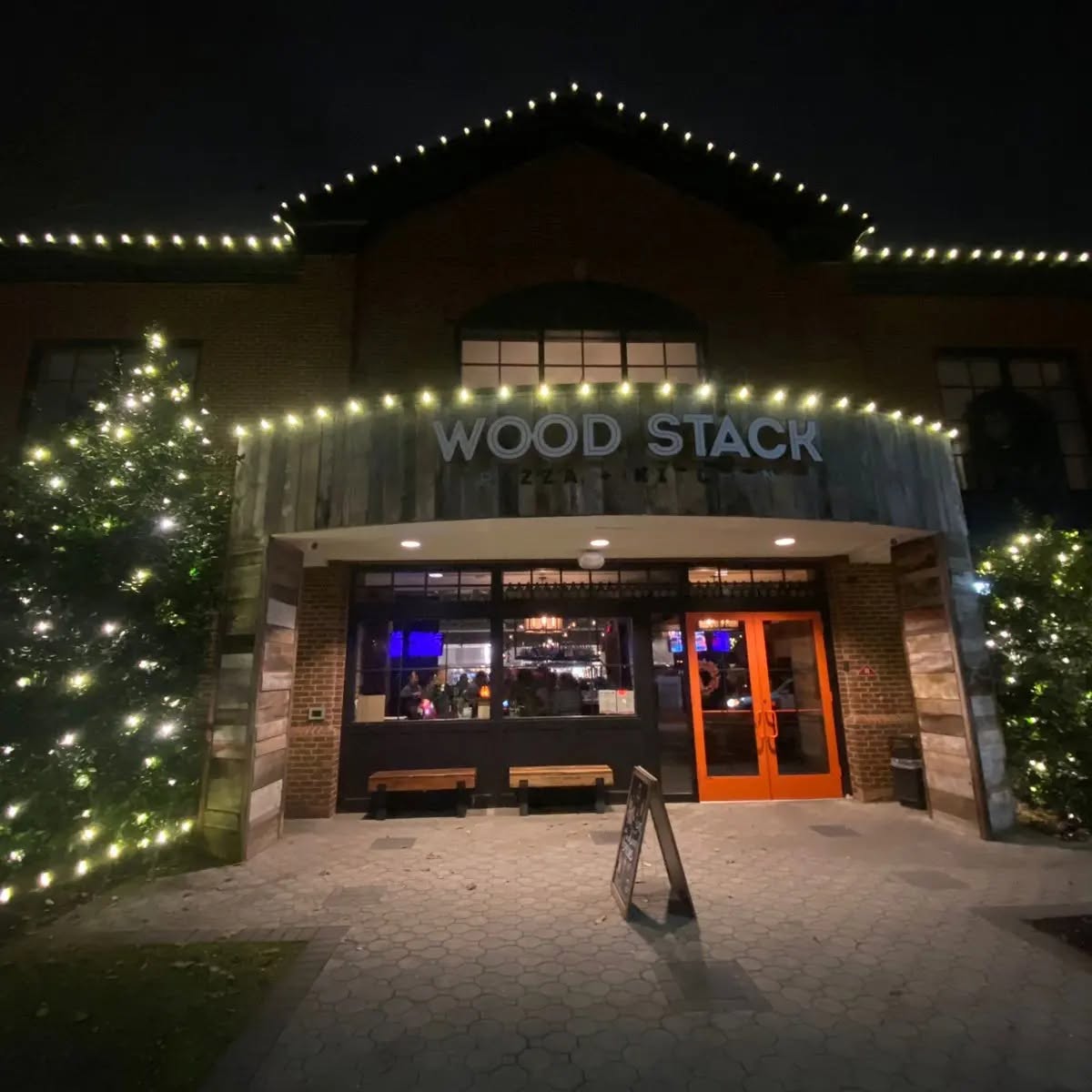 Restaurant entrance and walkway lit with warm white holiday lights