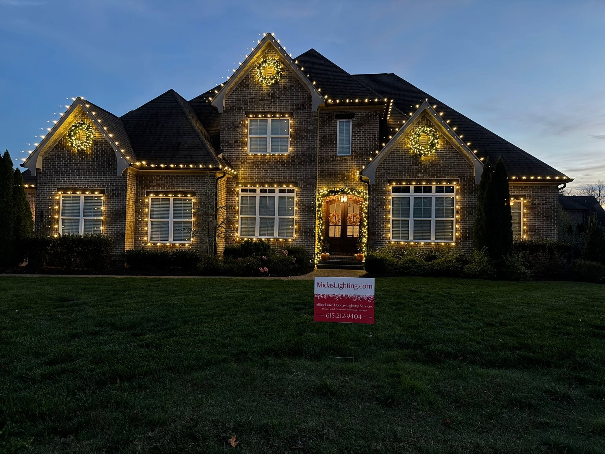 Brick home with warm white roofline Christmas lights installed by Midas